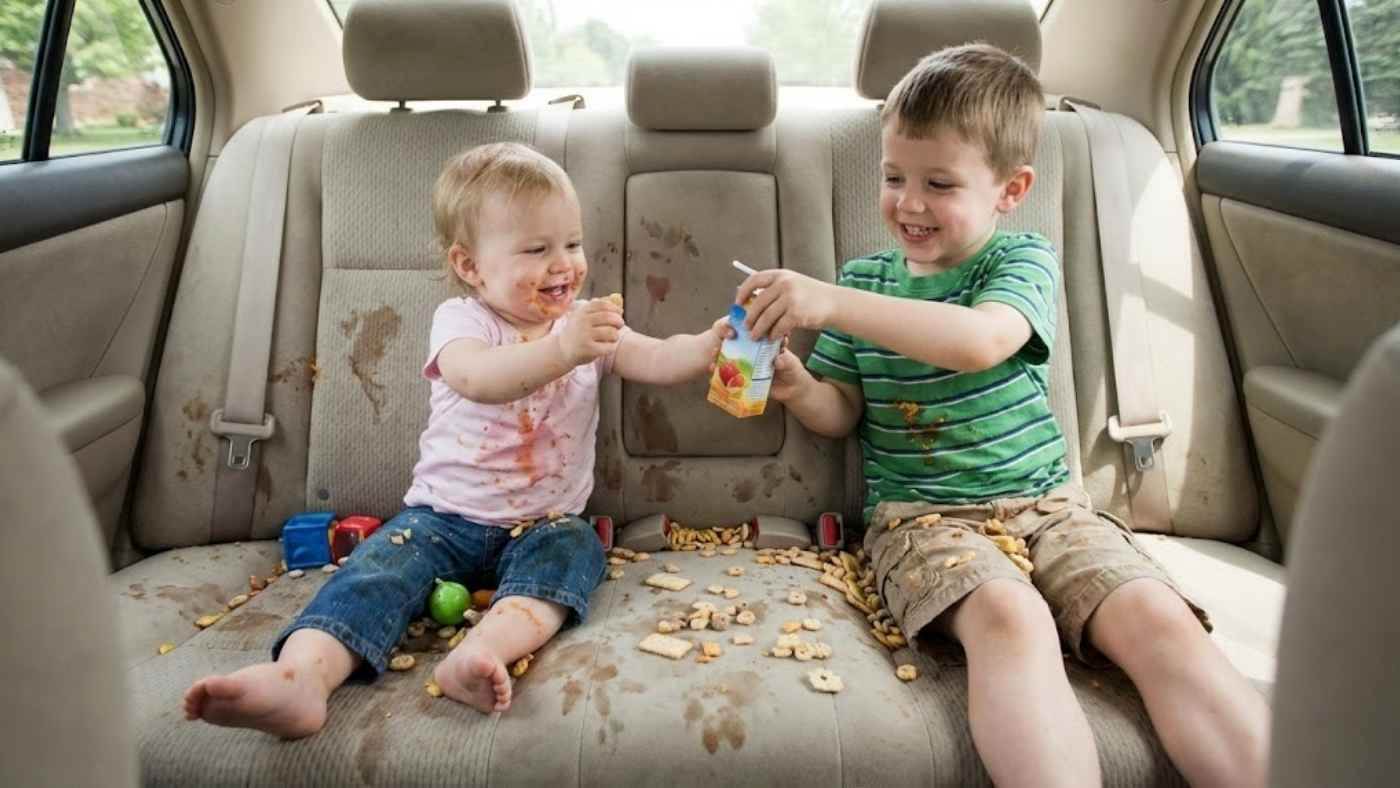 Kids spilling juice and snacks on car seat, showing why seat covers for families help protect against stains and crumbs.
